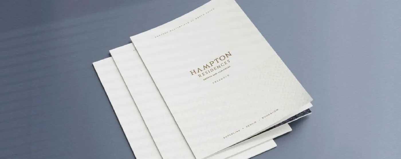 Foil-stamped Hampton Residences brochures, fanned on a table
